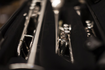 Three silver plated trumpets on a black case