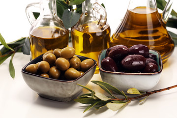 Olives. Bottle virgin olive oil and oil in a bowl with some olives