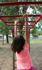 Fototapeta premium little girl with a pink shirt makes gym exercises