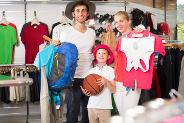 Positive parents with boy shopping hiking goods
