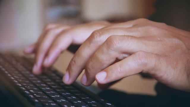 man typing on the keyboard. hands of a young man close up