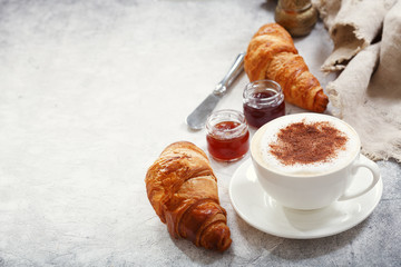 Cup of cappuccino coffee with croissants