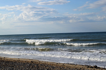 A beach with waves coming in on a cloudy day