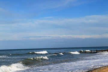 A beach with waves coming in on a cloudy day