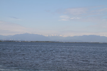 A view of a harbour with snow capped mountains