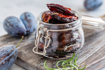 Glass jar with dried plums close-up.