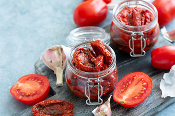 Sun dried tomatoes with herbs and olive oil in jar.