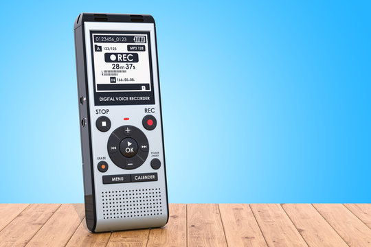 Modern digital voice recorder, dictaphone on the wooden table. 3D rendering