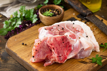 Fresh raw meat. Raw pork meat steak with olive oil, spices and herbs on wooden table. Copy space.