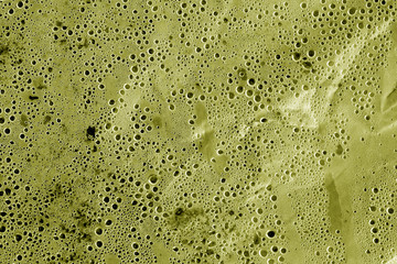 Condensation drops on plastic transparent material in yellow tone.