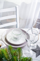 Christmas wreath with toys on the table with Silver Christmas Table Setting with christmas decorations above light window