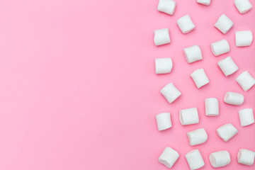 White marshmallows on a pink background. Copy space