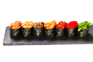 Set of sushi maki rolls at stone plate isolated at white background.