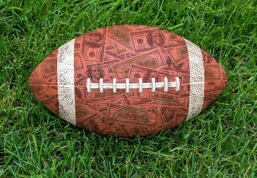 American football on grass with money pattern in brown leather