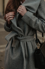 Woman holding her autumn coat closeup. Fashion style