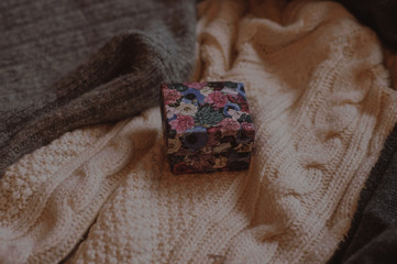 Closed christmas present box on the cozy sweater closeup