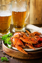 Boiled Crawfish and Fresh Beer in Beakers on a wooden table. Appetizer protein. Copy space.