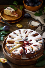 Delicious dessert plum pie, sweet delicious holiday cake with plums on wooden table.