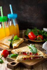 Concept of breakfast. Fruit Juice and delicious fresh Homemade Sandwich with tuna fish, tomatoes, cheese on a wooden kitchen table. Copy space.