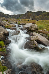 Moody landscape image of river flowing down mountain range near Llyn Ogwen and Llyn Idwal in Snowdonia in Autumn