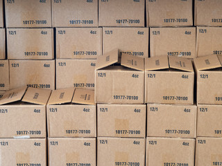 Rows and stacks of cardboard boxes sitting inside a warehouse
