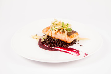 Baked salmon, beetroot mousse, black lentils and pear on a white background