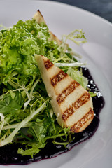 A mountain of greenery, arugula, lettuce with an abundance of unusual berry, blueberry sauce. Thin slices, chicken, white meat, fish, grilled. Dietary salad for those who lose weight.