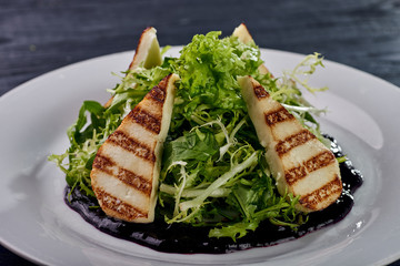 A mountain of greenery, arugula, lettuce with an abundance of unusual berry, blueberry sauce. Thin slices, chicken, white meat, fish, grilled. Dietary salad for those who lose weight.