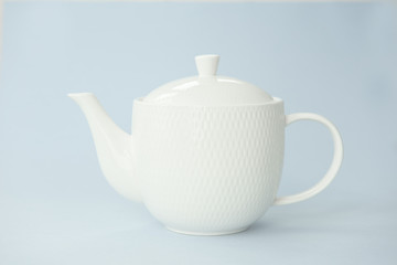 Pure white teapot on blue background. Close up