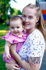 Young mother playing with her baby in the park