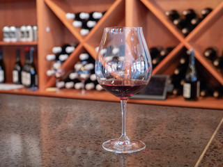 Small tasting glass of red wine on bar counter
