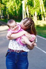 Fototapeta premium Young mother playing with her baby in the park