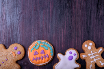 Assortment of gingerbread cookies with multicoloured glazing for Halloween against the dark background