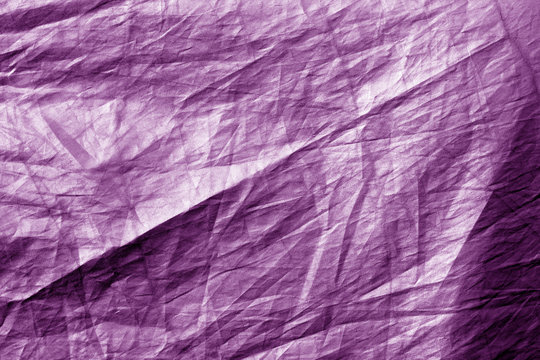 Crumpled plastic textile texture in purple tone.