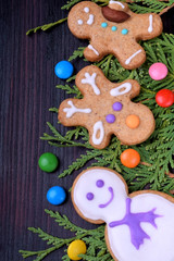 Cute Christmas gingerbread cookies and multicoloured sweets against the dark background
