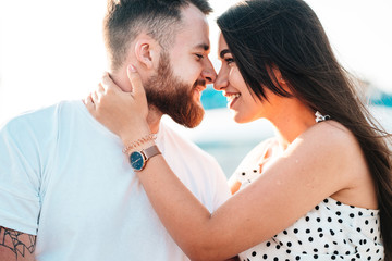 Handsome guy and beautiful girls kissing on the background of a fountain