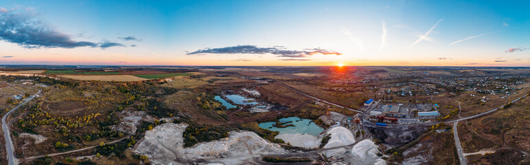 Aerial panorama of industrial chalk quarry or chalkpit for limestone mining and beautiful nature landscape at sunset, view from above