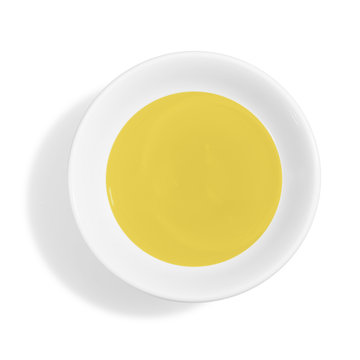 Olive oil in white ceramic bowl isolated on white background