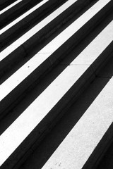 Stair treads close up. Black and white background in minimalist style. Symmetrical lines of light and shadow. Abstract background