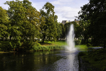 Obraz premium View of a beautiful autumn park with a lake with a fountain.