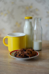 Biscuits, a yellow mug and bottles of milk.
