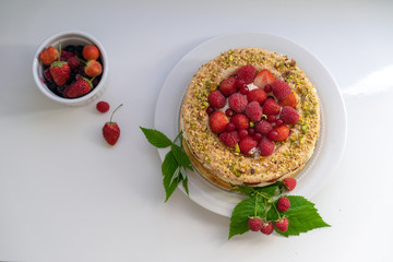 Delicious home made cake with fresh strawberries and rasberries on the white background. Isolated