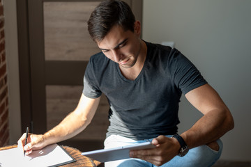 Handsome businessman with tablet and notebook working from home