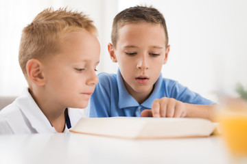 Little boys reading a book.