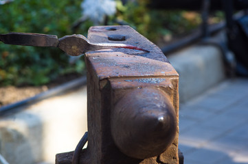blacksmith performs the forging of hot glowing metal on the anvil