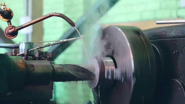 Turner is working on a turning lathe at the metal constructions factory. Heavy industry and metalwork. Accuracy metal cutting and detail drilling