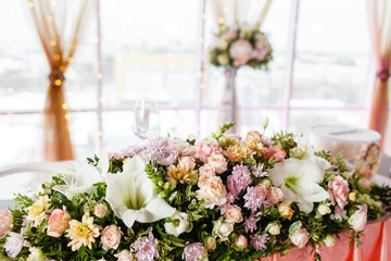 The table of the newlyweds. Table setting at a luxury wedding reception. Beautiful flowers on the table.