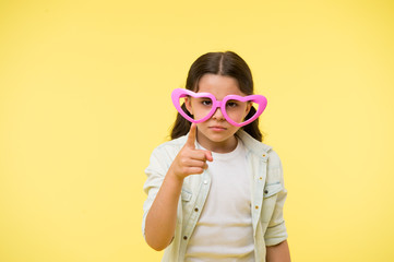 You send me valentines card. Child calm strict face pointing forward yellow background. Kid strictly warning you. Kid heart shaped eyeglasses celebrates valentines day. Do not forget valentines day