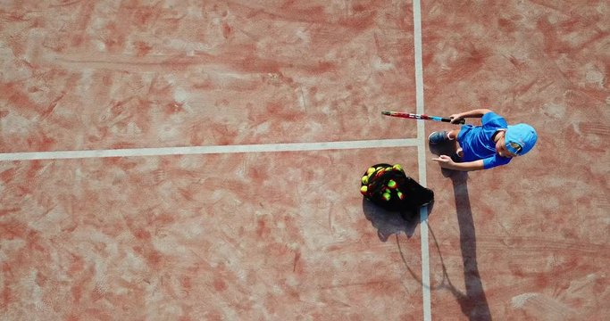 Little boy playing tennis. Little boy in tennis serving. Aerial view.