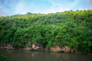 Fototapeta na wymiar mountain slope on jungle river 